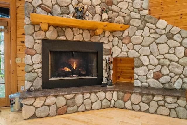 interior details with a stone fireplace and wooden walls