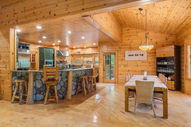 dining area featuring lofted ceiling, wood ceiling, wooden walls, and light hardwood / wood-style floors