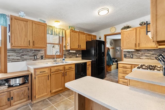 kitchen with tasteful backsplash, sink, light tile patterned floors, and black appliances