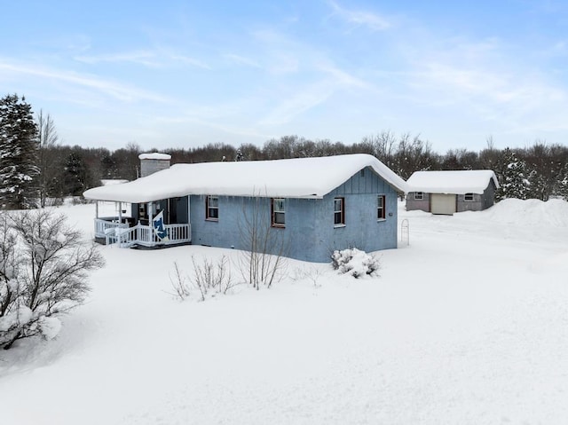 snow covered property with covered porch