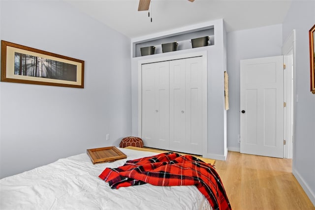 bedroom with light hardwood / wood-style floors, a closet, and ceiling fan