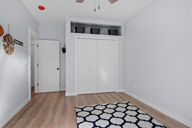 unfurnished bedroom featuring light hardwood / wood-style floors, a closet, and ceiling fan