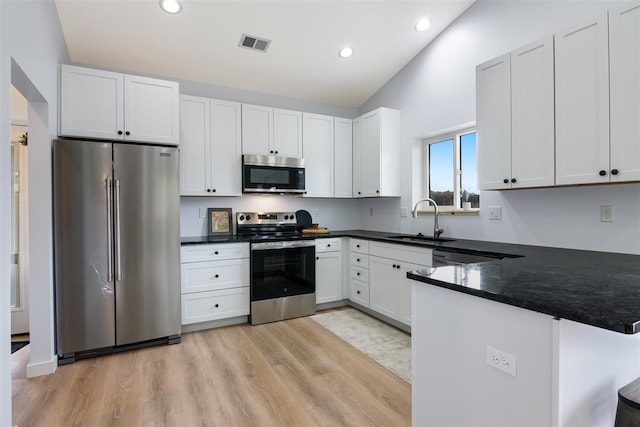 kitchen with stainless steel appliances, white cabinetry, and sink