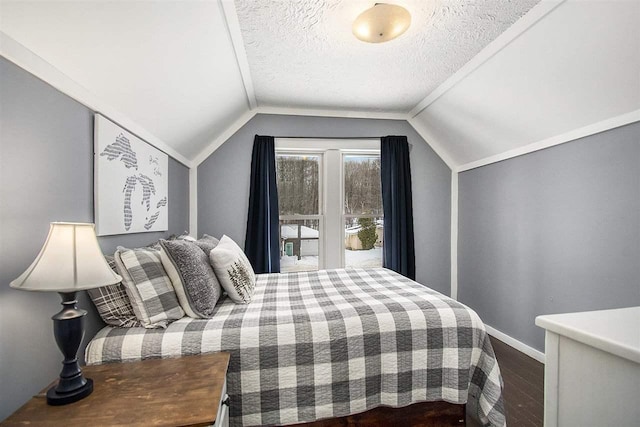 bedroom featuring vaulted ceiling, hardwood / wood-style floors, and a textured ceiling