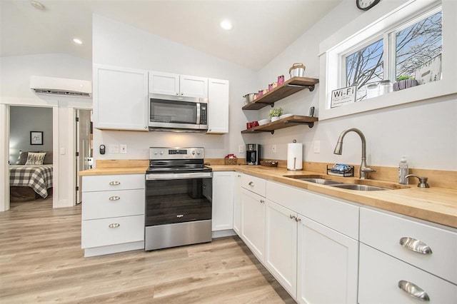 kitchen with butcher block countertops, stainless steel appliances, and white cabinets