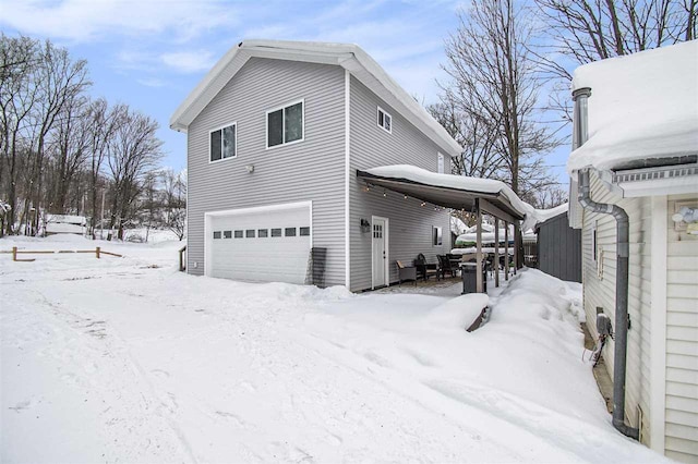 view of snow covered exterior featuring a garage