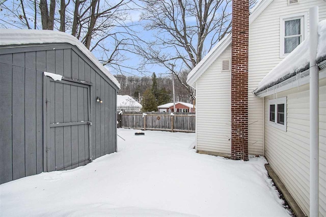 snowy yard with a shed