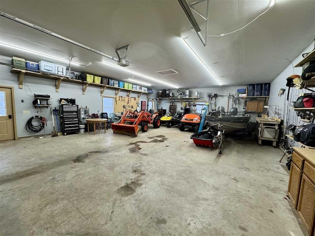 garage with a garage door opener and a workshop area