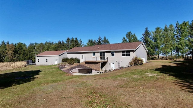 back of property with a wooden deck and a yard