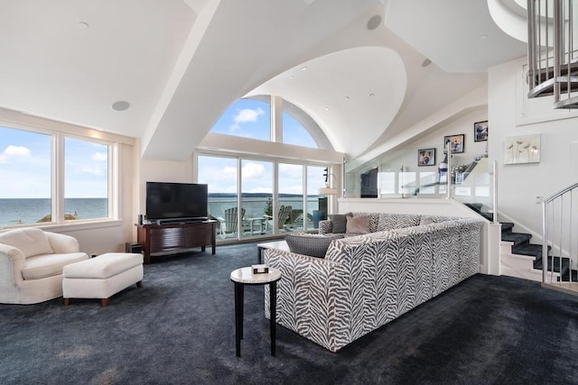 living room featuring lofted ceiling, a wealth of natural light, dark colored carpet, and a water view