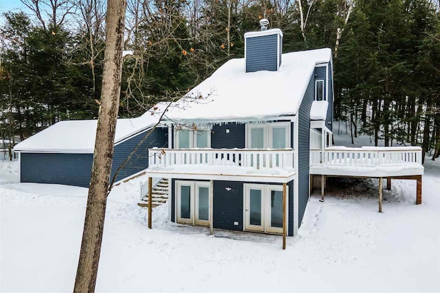 snow covered property featuring a wooden deck and french doors