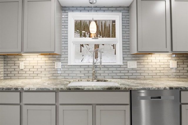 kitchen with sink, tasteful backsplash, decorative light fixtures, dishwasher, and light stone countertops