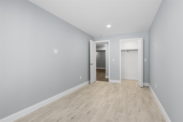 unfurnished bedroom with a closet and light wood-type flooring