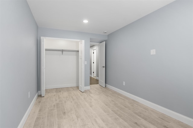 unfurnished bedroom featuring a closet and light hardwood / wood-style flooring