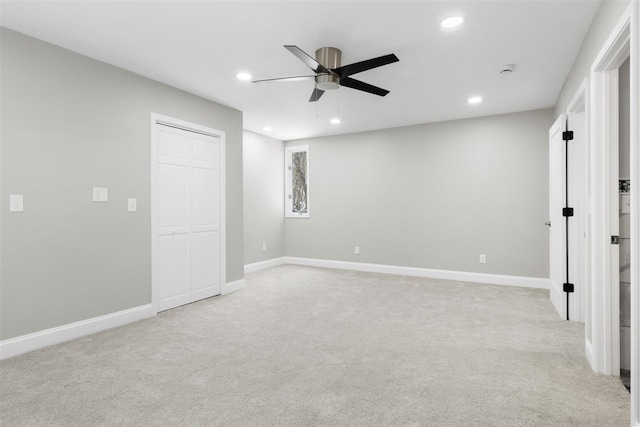 unfurnished bedroom featuring light carpet, a closet, and ceiling fan