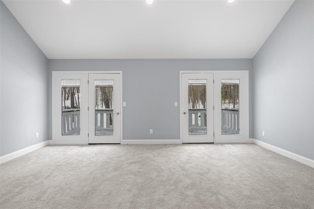 empty room with light carpet and vaulted ceiling