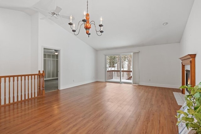 unfurnished living room featuring high vaulted ceiling, ceiling fan with notable chandelier, and light hardwood / wood-style floors