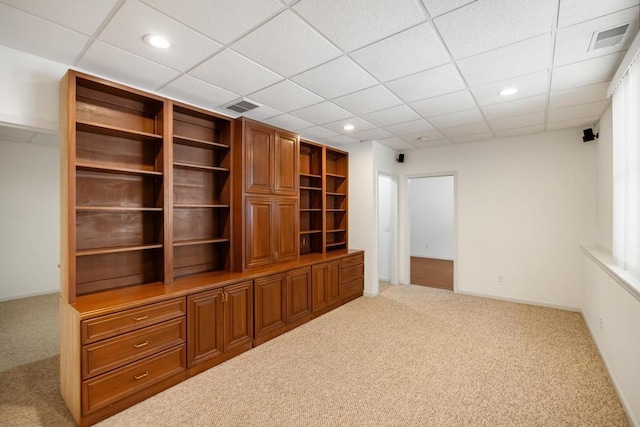 unfurnished living room with carpet and a drop ceiling