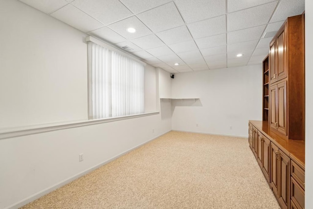 carpeted empty room with a paneled ceiling