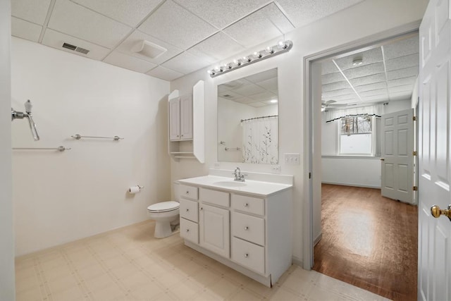 bathroom featuring vanity, a paneled ceiling, curtained shower, and toilet