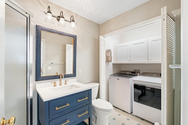 bathroom with vanity, washing machine and dryer, and toilet