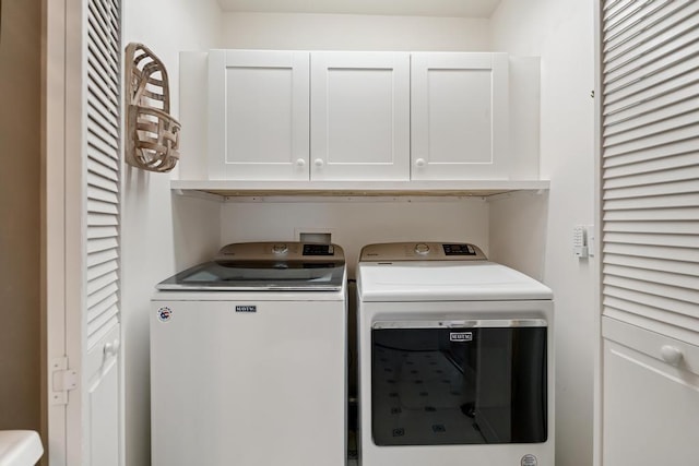 washroom featuring cabinets and separate washer and dryer