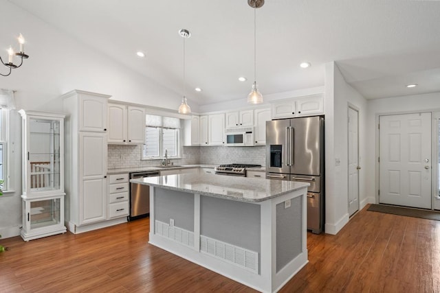 kitchen with white cabinetry, appliances with stainless steel finishes, sink, and hanging light fixtures