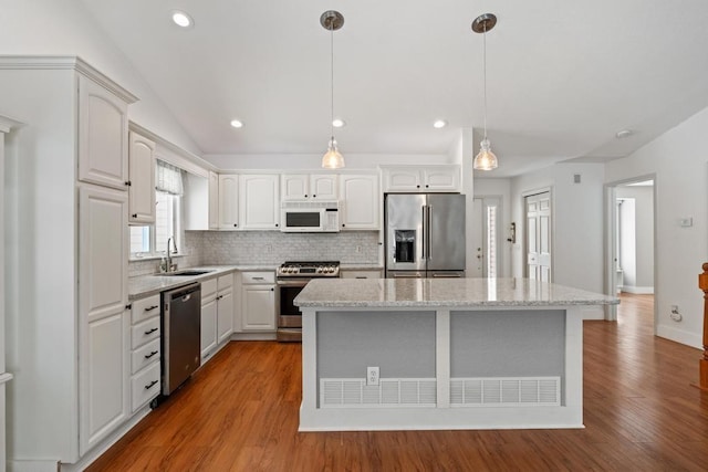 kitchen with white cabinetry, hanging light fixtures, and appliances with stainless steel finishes