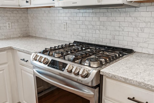 details featuring light stone counters, white cabinets, decorative backsplash, and stainless steel gas range oven