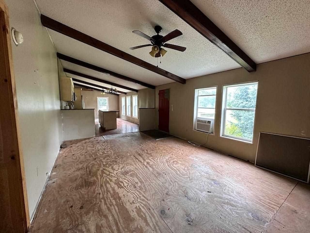 empty room with lofted ceiling with beams, ceiling fan, cooling unit, and a textured ceiling