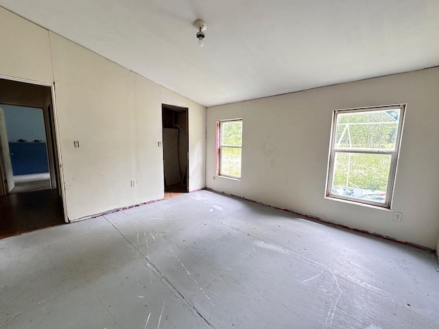 unfurnished room with lofted ceiling