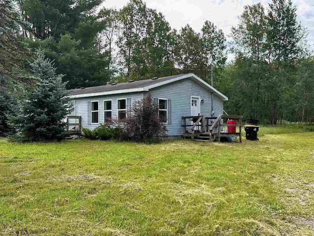 back of property with a yard and a deck