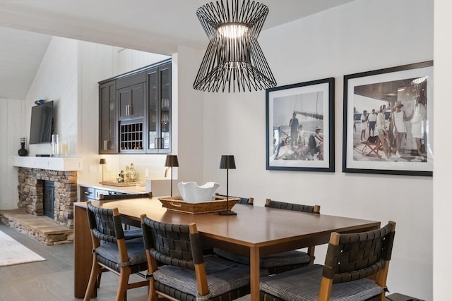 dining area featuring lofted ceiling, hardwood / wood-style flooring, and a fireplace