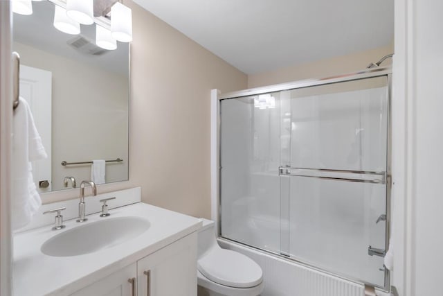 full bathroom with shower / bath combination with glass door, vanity, and toilet