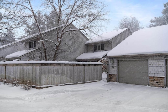 snow covered property featuring a garage