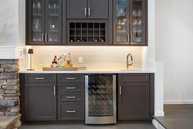 bar with tasteful backsplash, beverage cooler, and sink