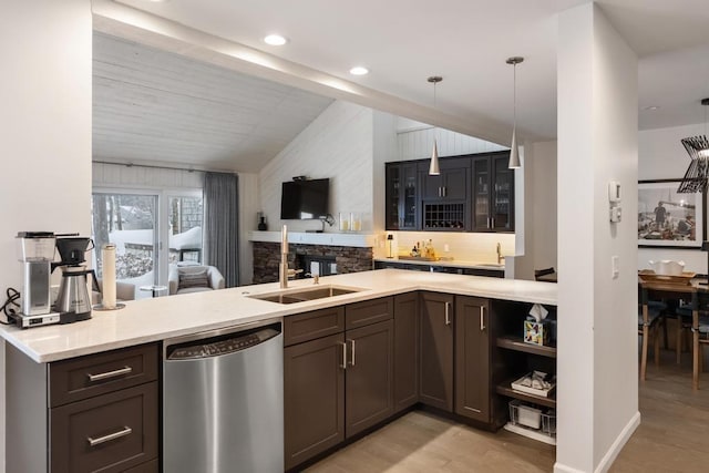 kitchen with lofted ceiling, sink, hanging light fixtures, stainless steel dishwasher, and light wood-type flooring