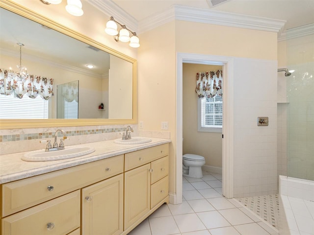 bathroom featuring crown molding, toilet, a healthy amount of sunlight, and tiled shower