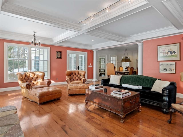 living room featuring hardwood / wood-style flooring, beam ceiling, decorative columns, coffered ceiling, and a notable chandelier