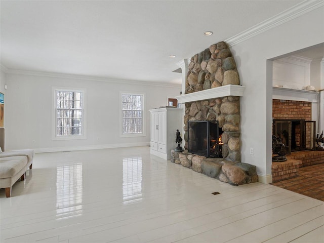 living room with crown molding and a stone fireplace