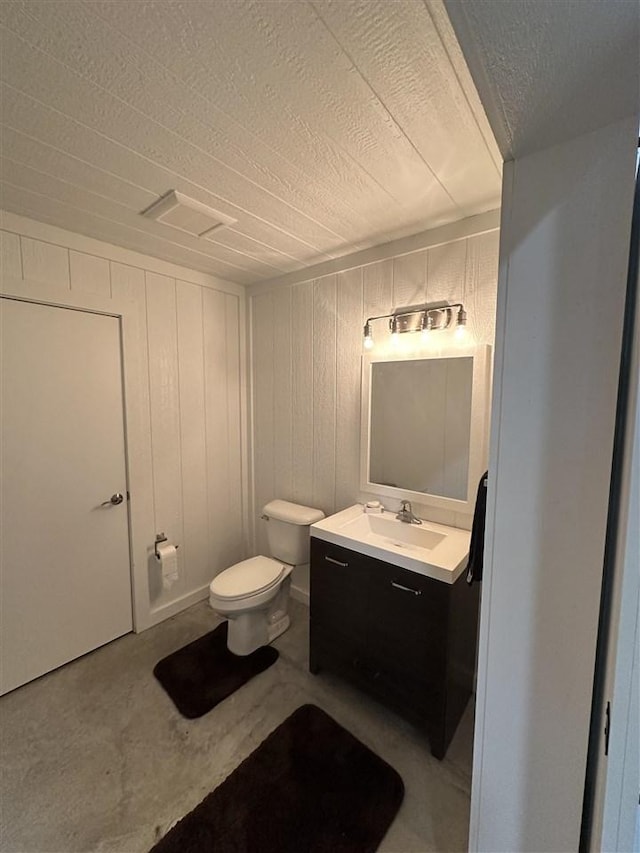 bathroom featuring vanity, concrete floors, and toilet