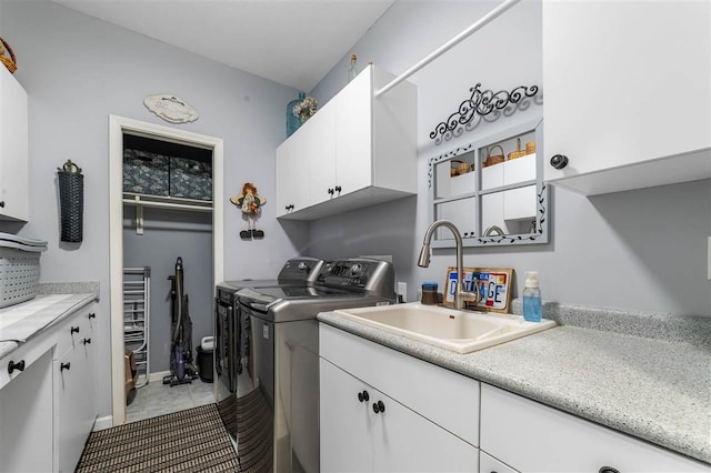 laundry area with cabinets, washing machine and dryer, sink, and light tile patterned flooring