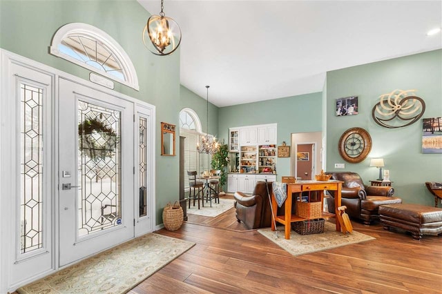 entrance foyer with a high ceiling, hardwood / wood-style floors, and a notable chandelier