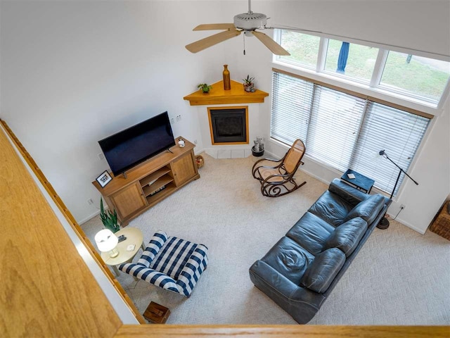 living room featuring a high ceiling, carpet floors, and ceiling fan