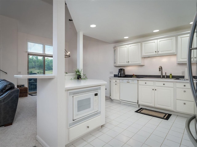 kitchen featuring white cabinetry, sink, light tile patterned floors, and white appliances