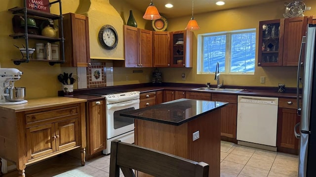 kitchen featuring recessed lighting, light tile patterned floors, a sink, white appliances, and a kitchen island
