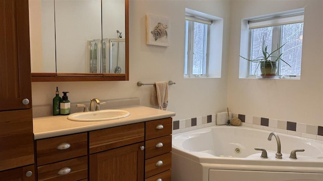 bathroom featuring a tub with jets and vanity