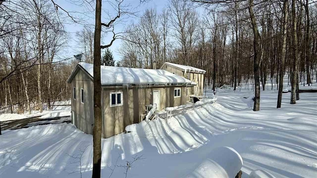 view of snowy exterior featuring an outbuilding
