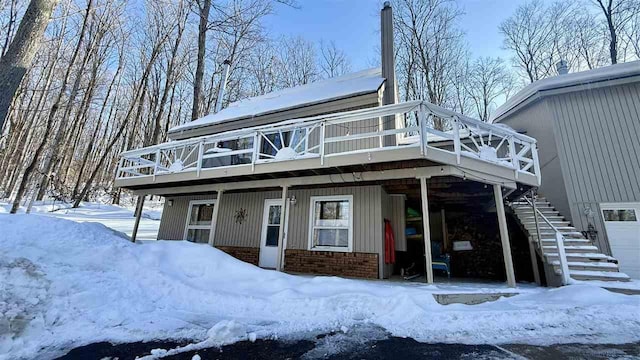view of front of home featuring a wooden deck, brick siding, and stairs