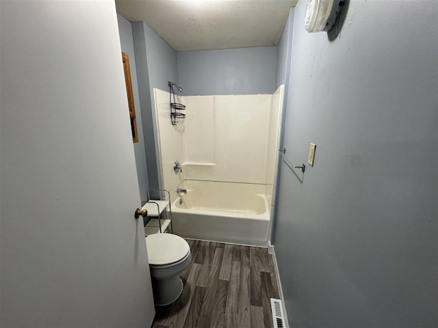 bathroom with wood-type flooring, toilet, and shower / bath combination